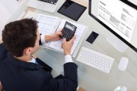 High,Angle,View,Of,Businessman,Calculating,Tax,At,Desk,In